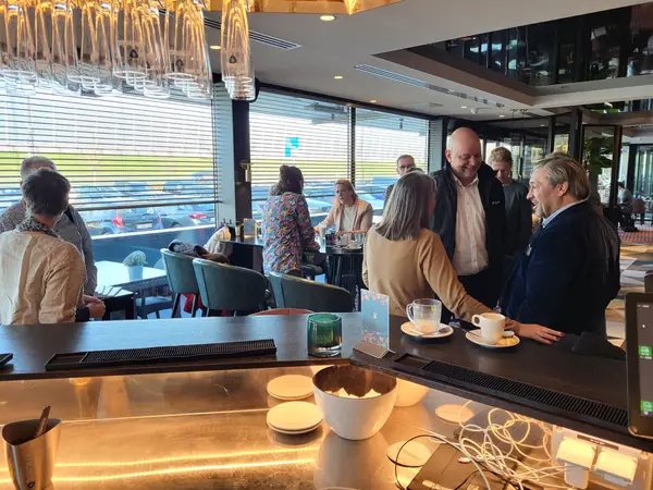 Lachende mannen en vrouw in gesprek aan de bar